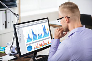 A young man analyzing data on a computer