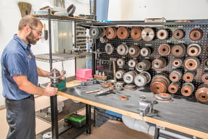 A Tru-Edge worker at a workbench with new and used saws