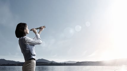 A woman using a telescope to look at the sky